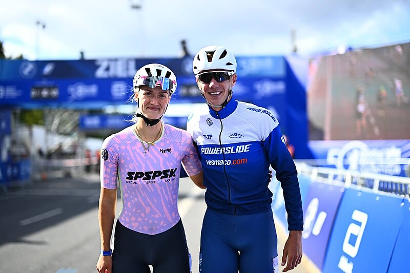 Noraly Berber Vonk and Bart Swings stand in front of the goal and smile at the camera.