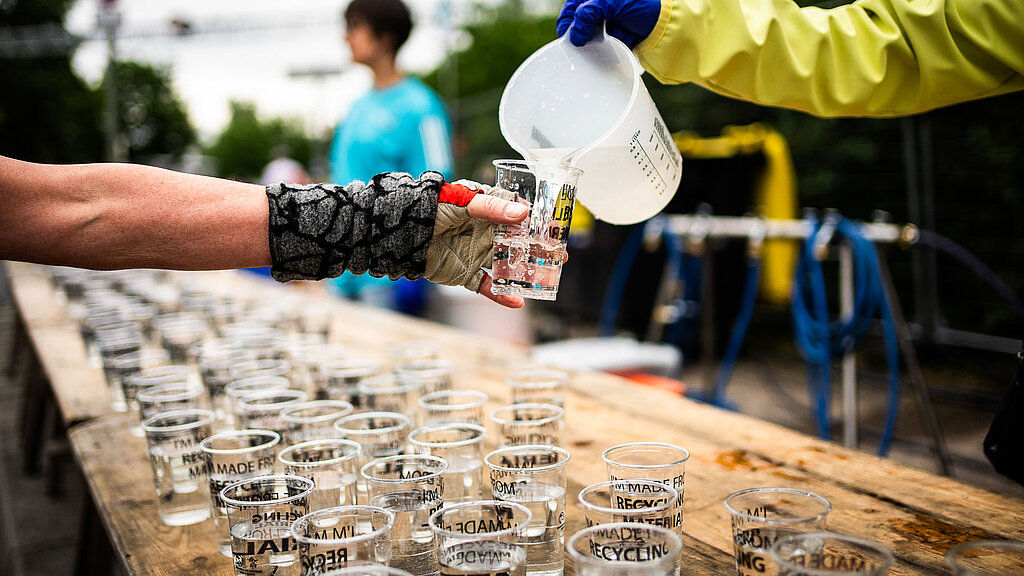 Am Versorgungspunkt wird ein Becher mit Wasser aufgefüllt © SCC EVENTS / Sebastian Wells/OSTKREUZ