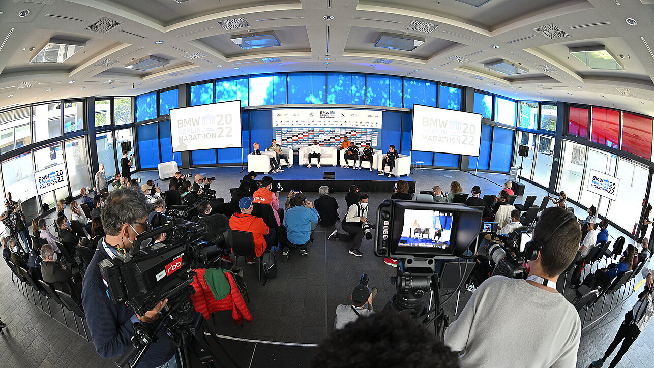Bühne mit Interviewgästen bei Pressekonferenz. Bühne, Zuschauer und Medien bei der Pressekonferenz der Top-Athleten des BMW BERLIN-MARATHON. ©Petko Beier / SCC EVENTS