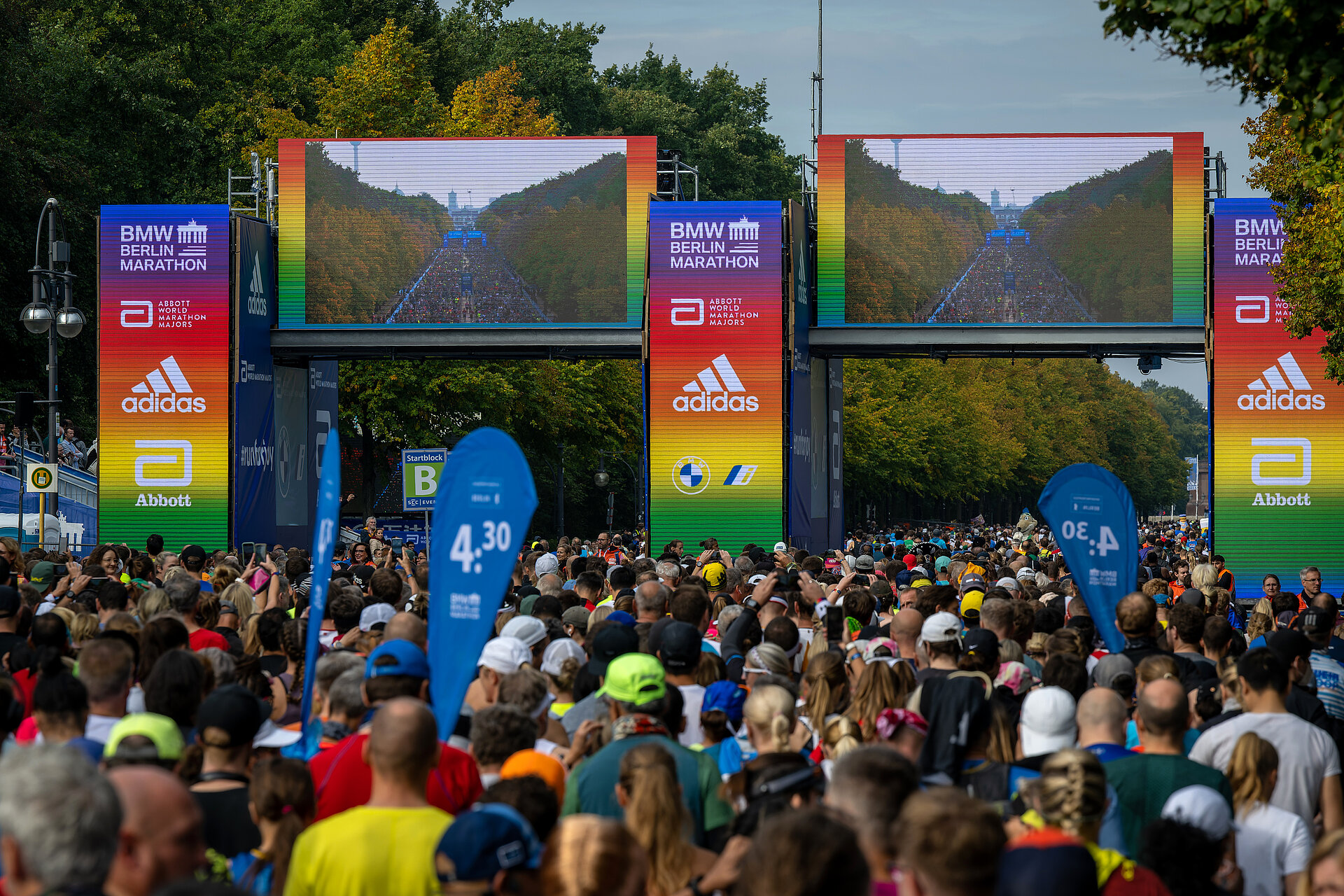 Start gate of the BMW BERLIN-MARATHON shining in rainbow colours Lot’s of running people go through the start gate, which glows in rainbow colours.