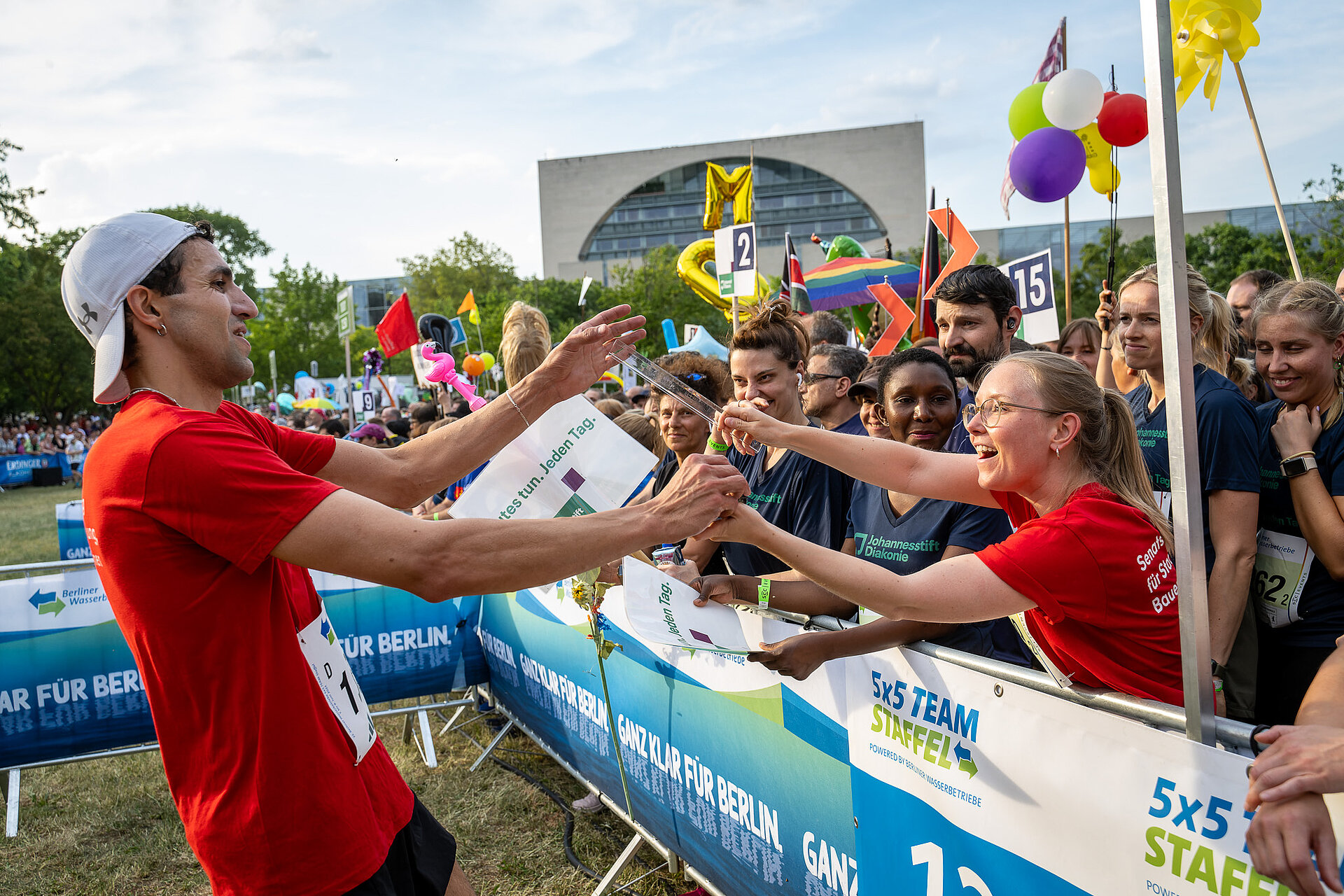 Handing over the baton in the 5x5 team relay on the Reichstag lawn.