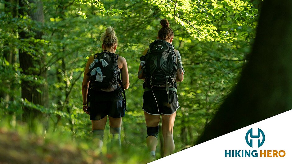 Zwei Frauen bei Wanderung mit Rucksack auf einem Waldweg ©SCC EVENTS