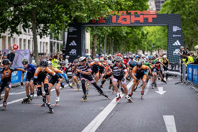 Inline skaters shortly after the start of the adidas Runners City Night, with the starting gate in the background