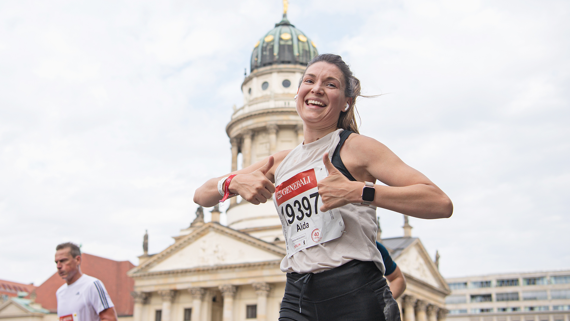 Eine vor Glück strahlende Läuferin vor dem Berliner Schloss.  Glückliche Läuferin auf der GENERALI BERLINER HALBMARATHON Strecke vor dem Berliner Schloss. ©Annegret Hilse / SCC EVENTS