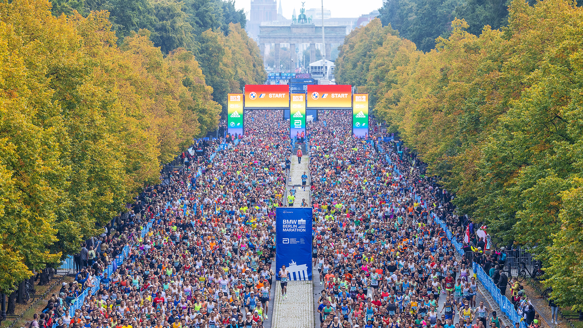 The start of the BMW BERLIN-MARATHON in front of the Brandenburg Gate. The start of the BMW BERLIN-MARATHON with the start gate in rainbow colours and the Brandenburg Gate in the background. ©Norbert Wilhelmi / SCC EVENTS